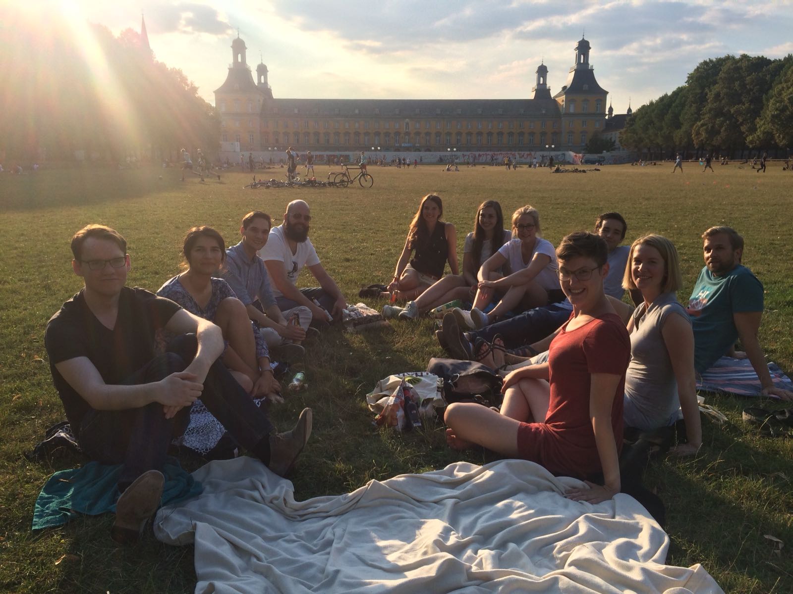 JEFer sitzen auf einer Picknickdecke im Hofgarten