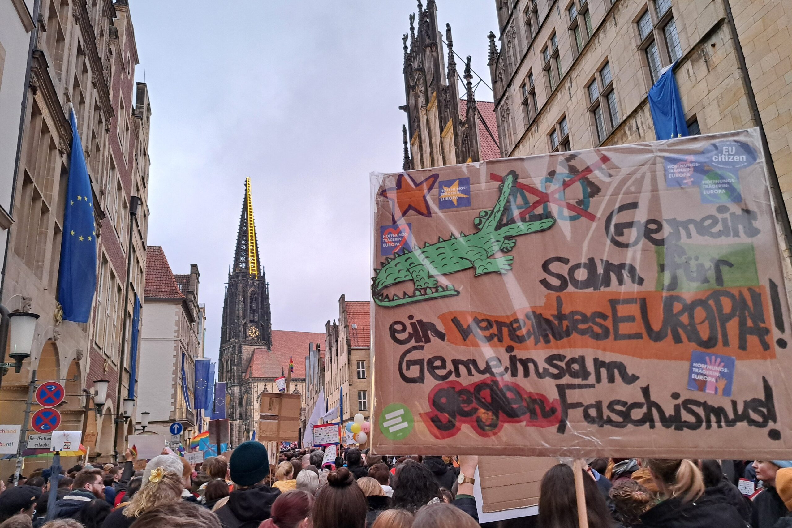 Bild von der Demo gegen die rechtsextreme AfD auf dem Prinzipalmarkt in Münster und ein Demoplakat mit der Aufschrift "Gemeinsam für ein vereintes Europa. Gemeinsam gegen Faschismus"